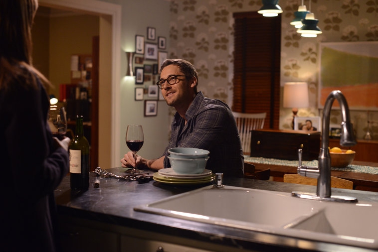 Tom (Ryan Eggold) se détend un verre à la main