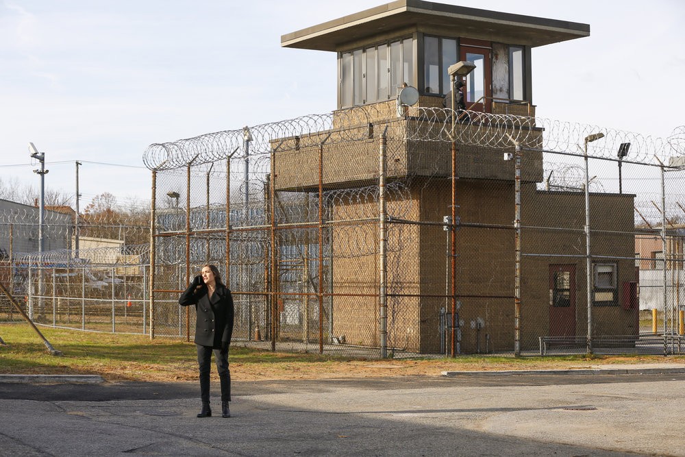 Elisabeth (Megan Boone),  dans la cour de la prison, téléphone