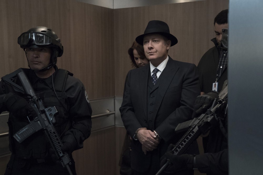 Cynthia Panabaker (Deirdre Lovejoy), Reddington (James Spader) et Harold Cooper (Harry Lennix) dans un ascenseur accompagnés de gardes armés