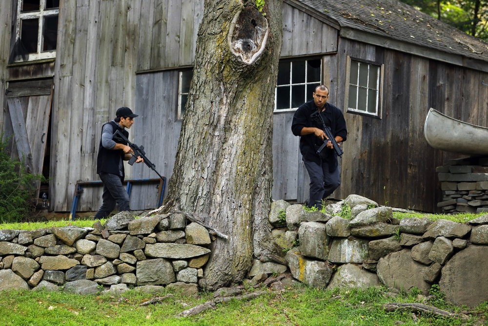 Des hommes armés encerclent une maison