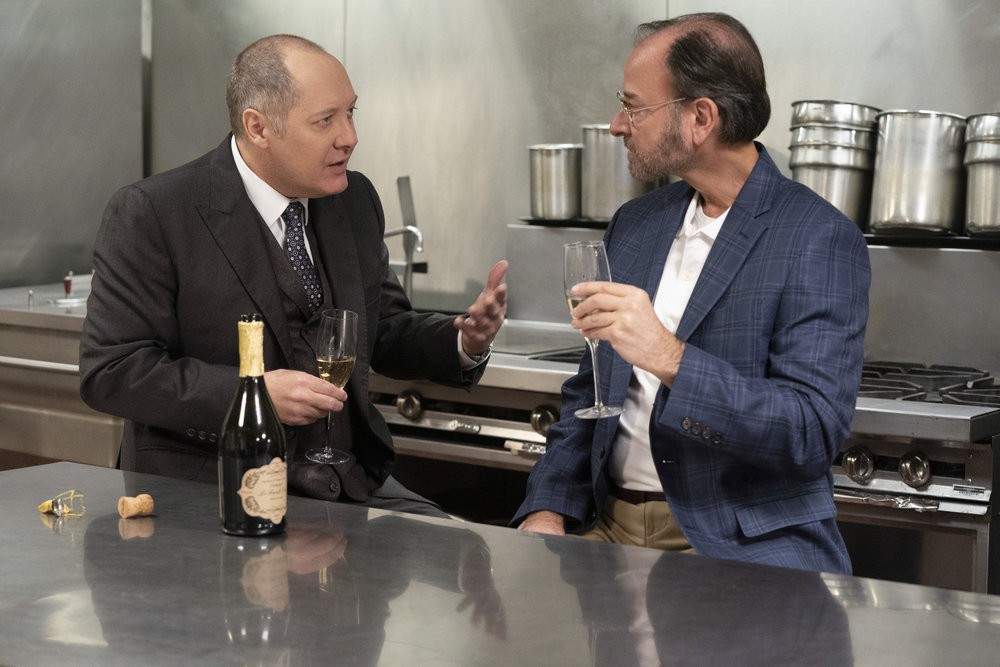 Red (James Spader) et Marvin Gerard (Fisher Stevens) discutent affaires autour d'une coupe de champagne