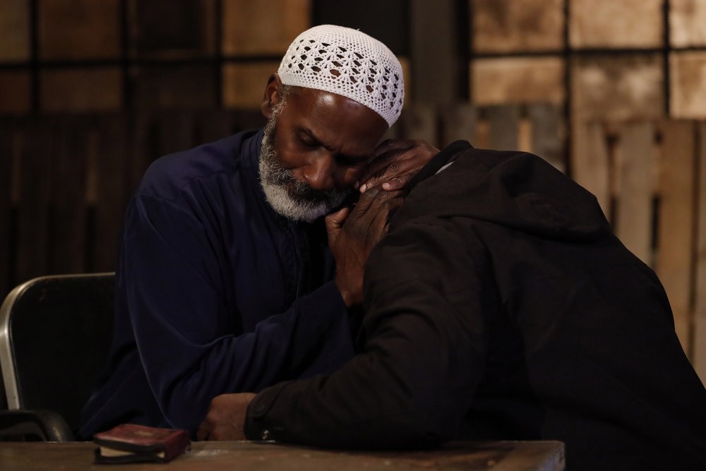  L'imam Sadiq Asmal (Harold Surratt) réconforte Dembe Zuma (Hisahm Tawfiq), accablé