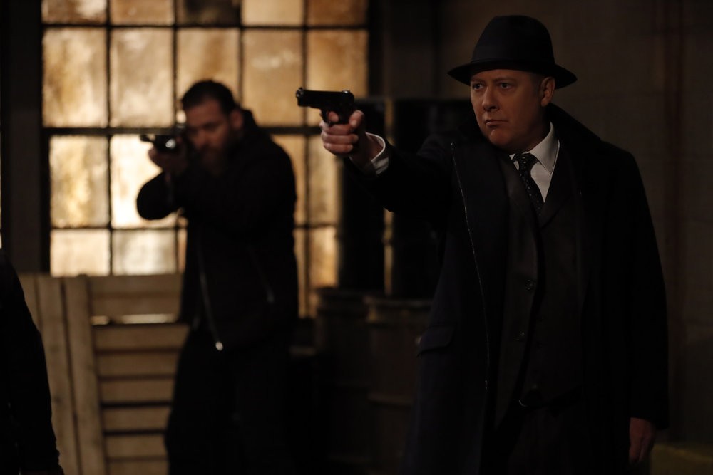 Raymond Reddington (James Spader) menaçant de son arme mais qui?