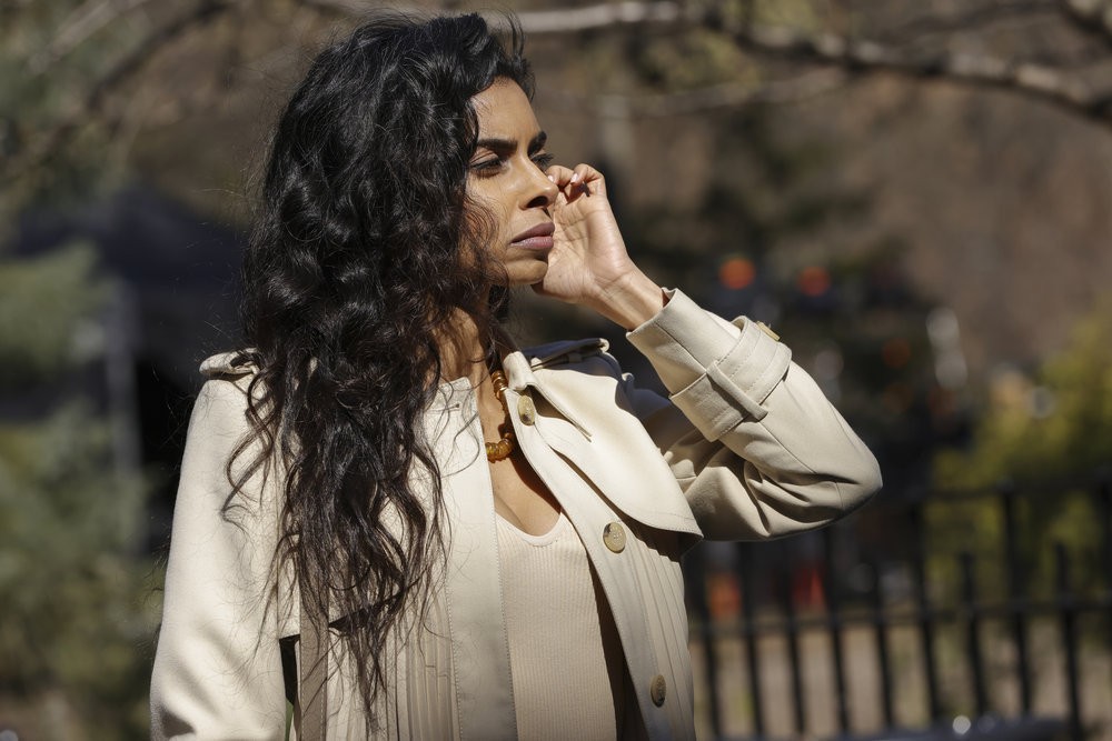 Priya Laghari (Rana Roy) au téléphone dans un parc
