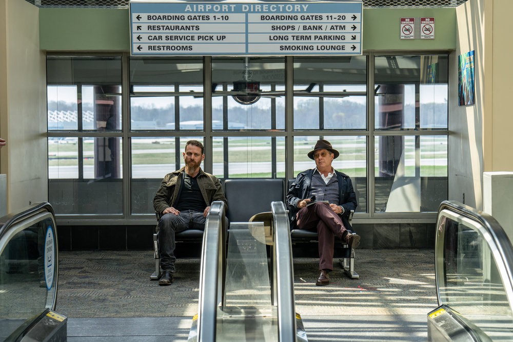 Chuck (Jonathan Holtzman) et son patron Reddington attendent, assis