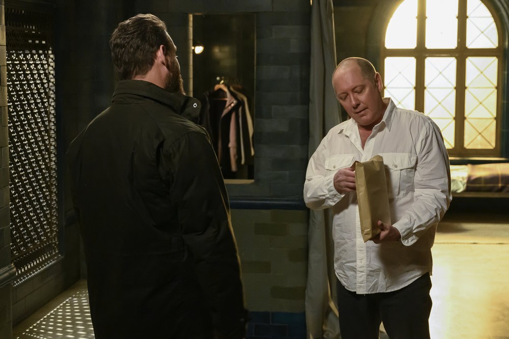 Chuck (Jonathan Holtzman) regarde son patron Raymond Reddington (James Spader) ouvrir le paquet qu'il lui a amené