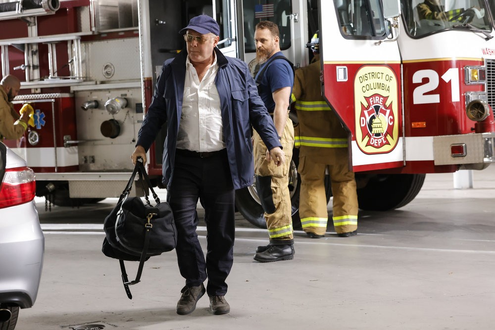 Chuck (Jonathan Holtzman) observe son patron Raymond Reddington (James Spader) alors qu'il se tient près d'un camion de pompier