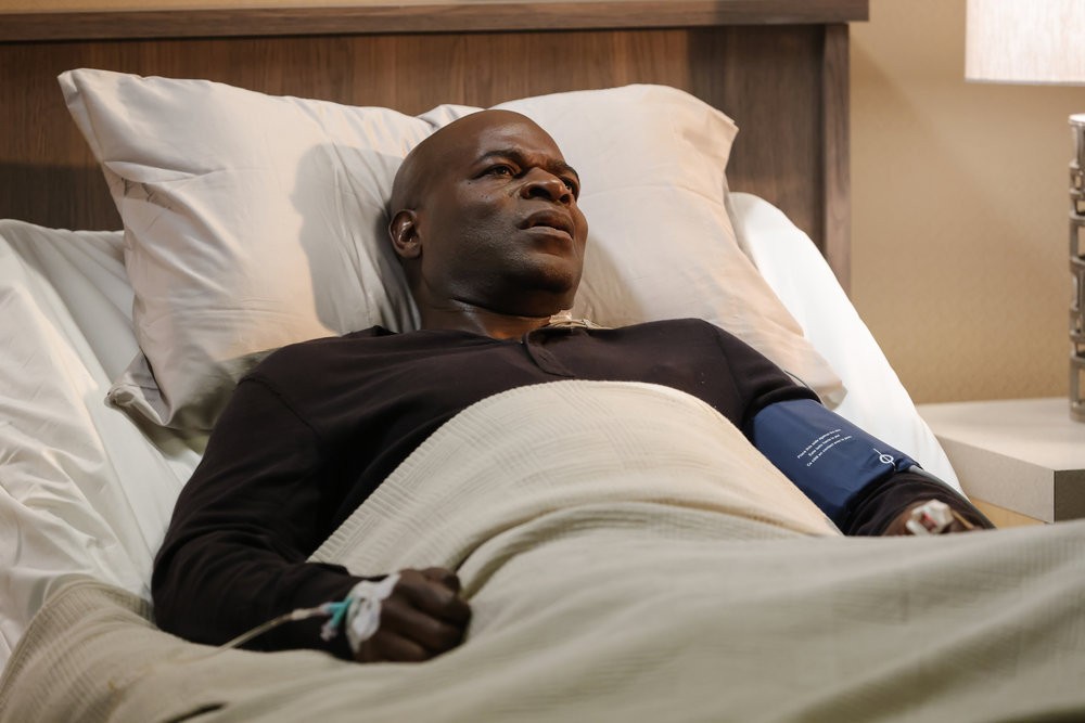 Dembe Zuma (Hisham Tawfiq) sur un lit d'hôpital