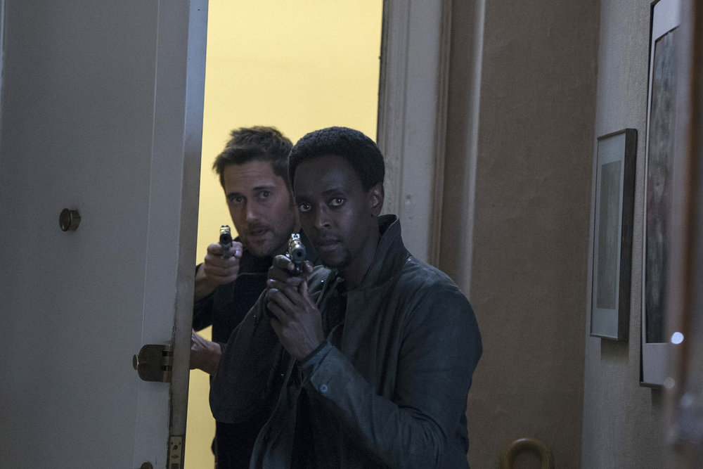 Matias Solomon (Edi Gathegi) et Tom Keen (Ryan Eggold) font irruption dans un appartement armes aux poings